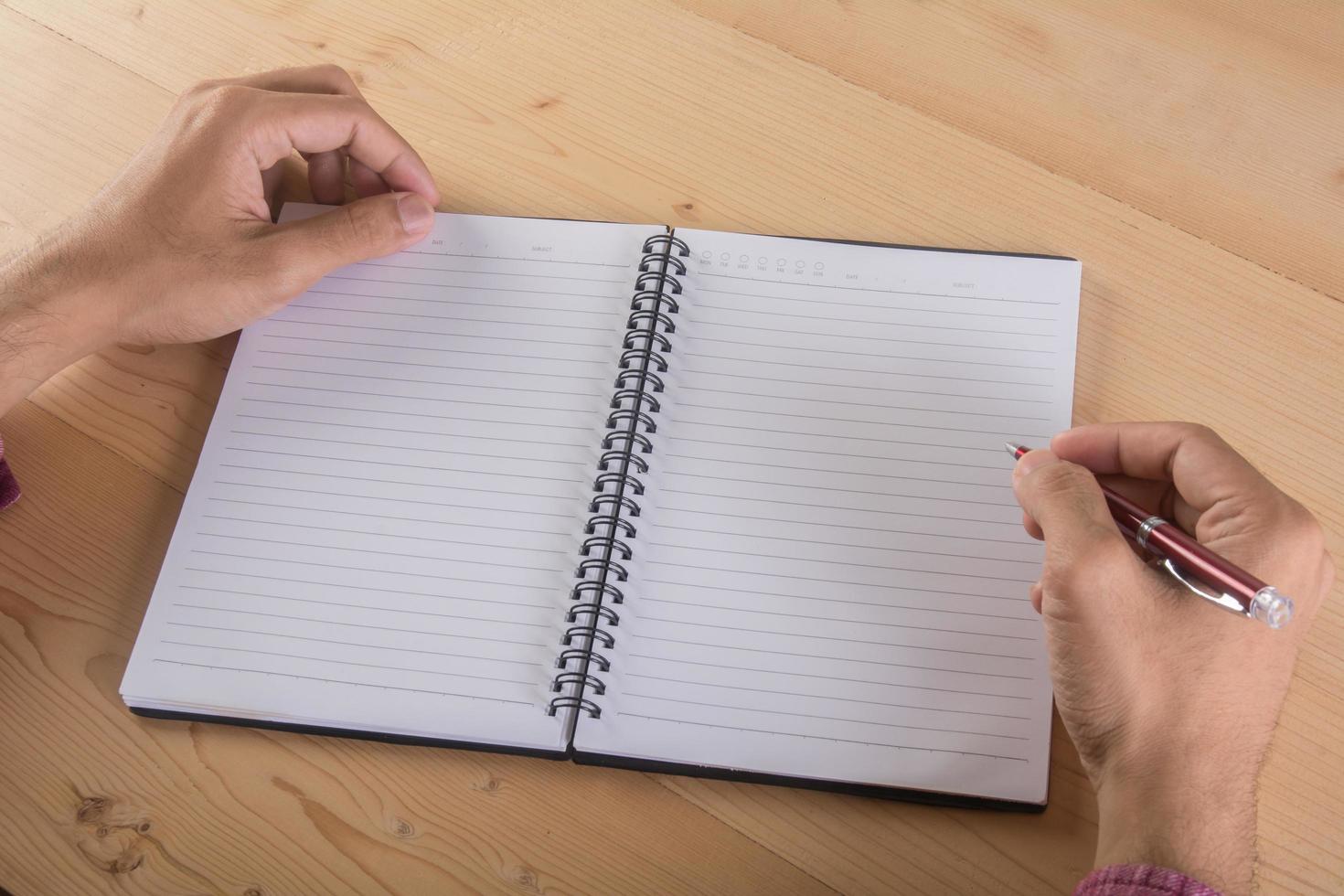 primer plano, de, hombre de negocios, escritura a mano, con, cuaderno foto