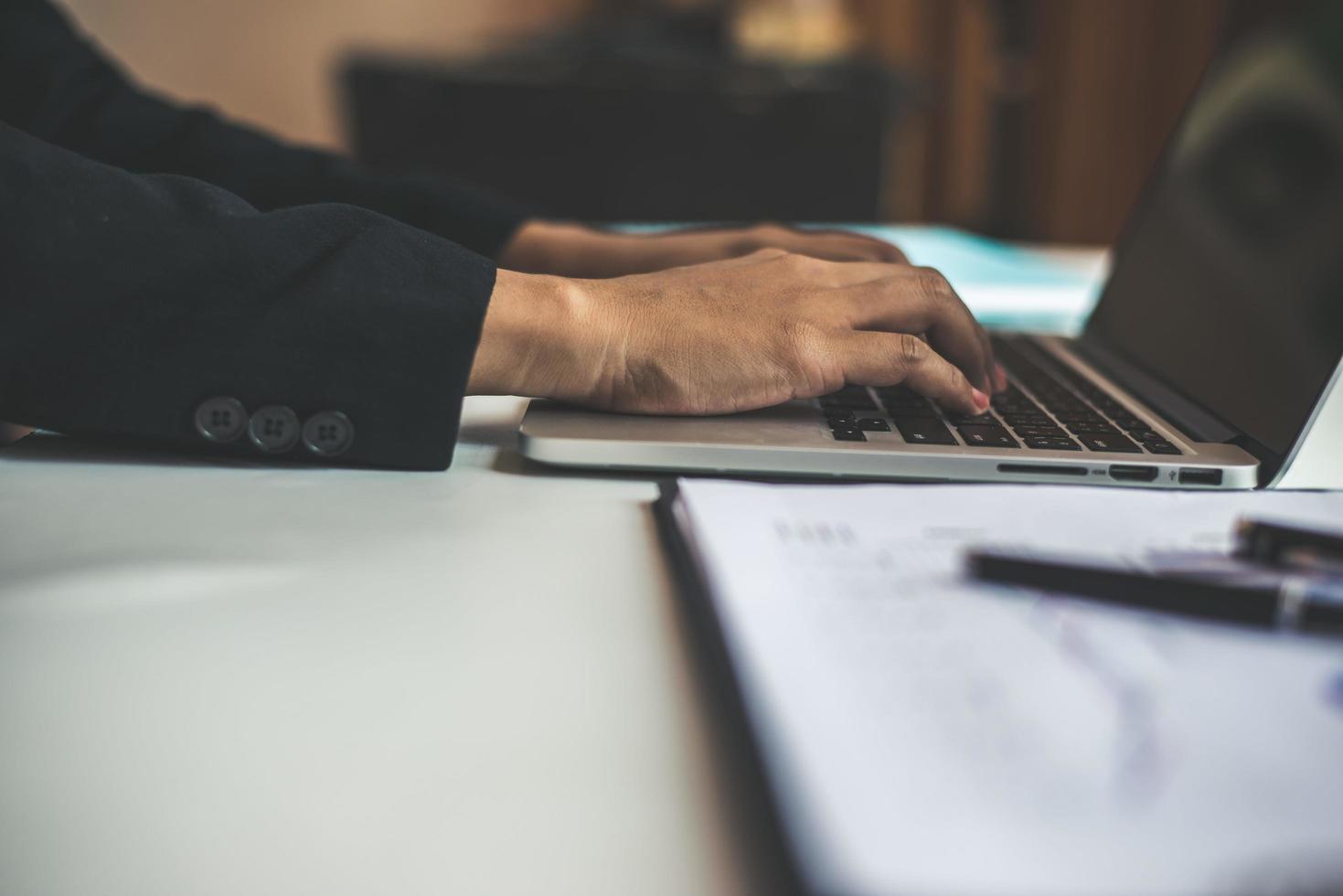 mujer de negocios, sentado, en el escritorio, y, trabajando, en, computadora foto