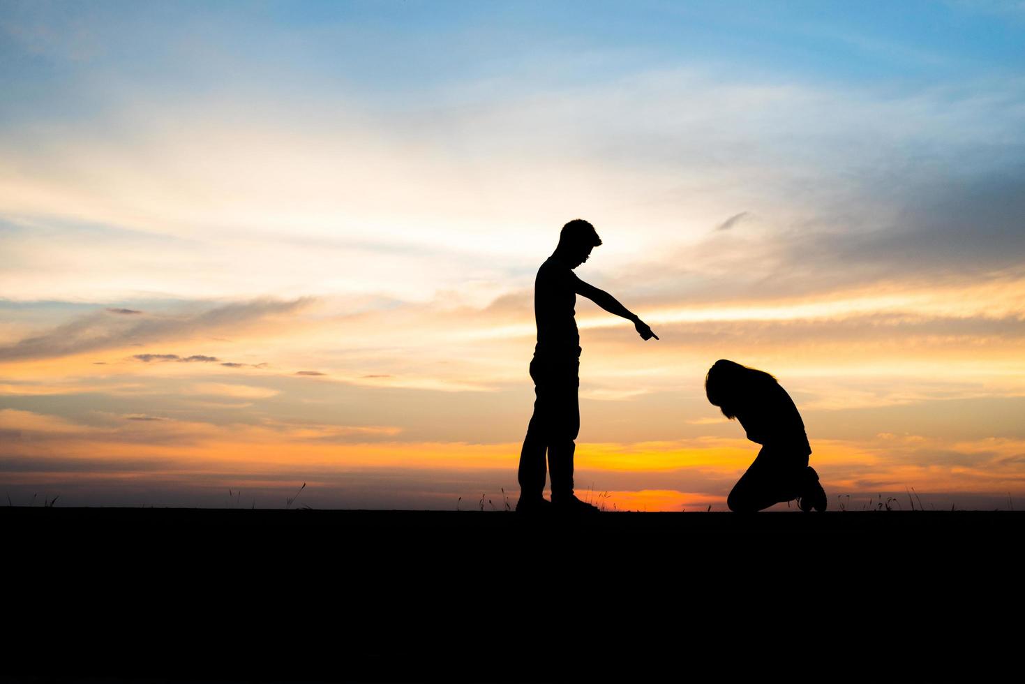 Silhouette of an upset couple in a quarrel at sunset photo