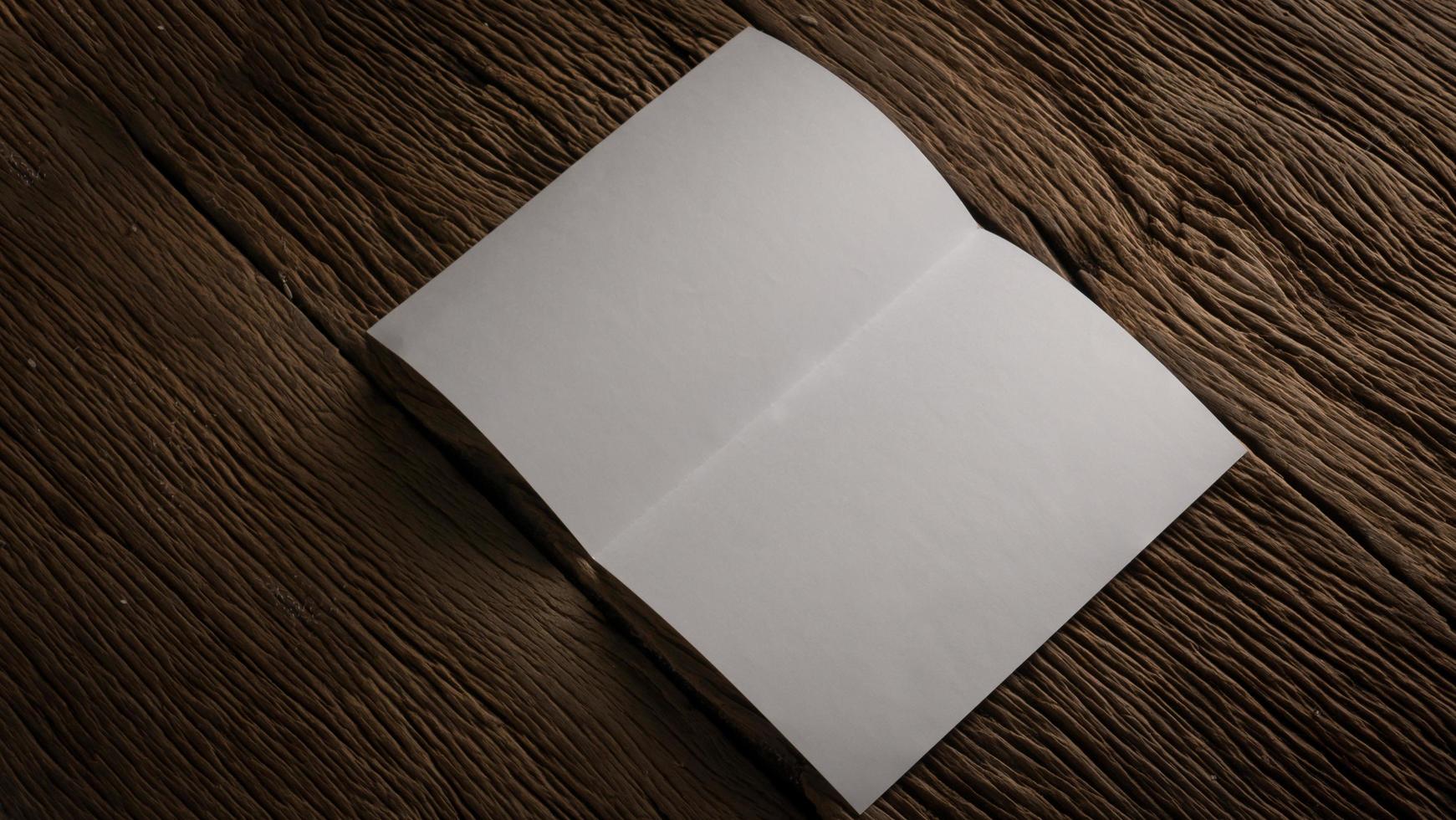 White blank folded paper on wooden table photo