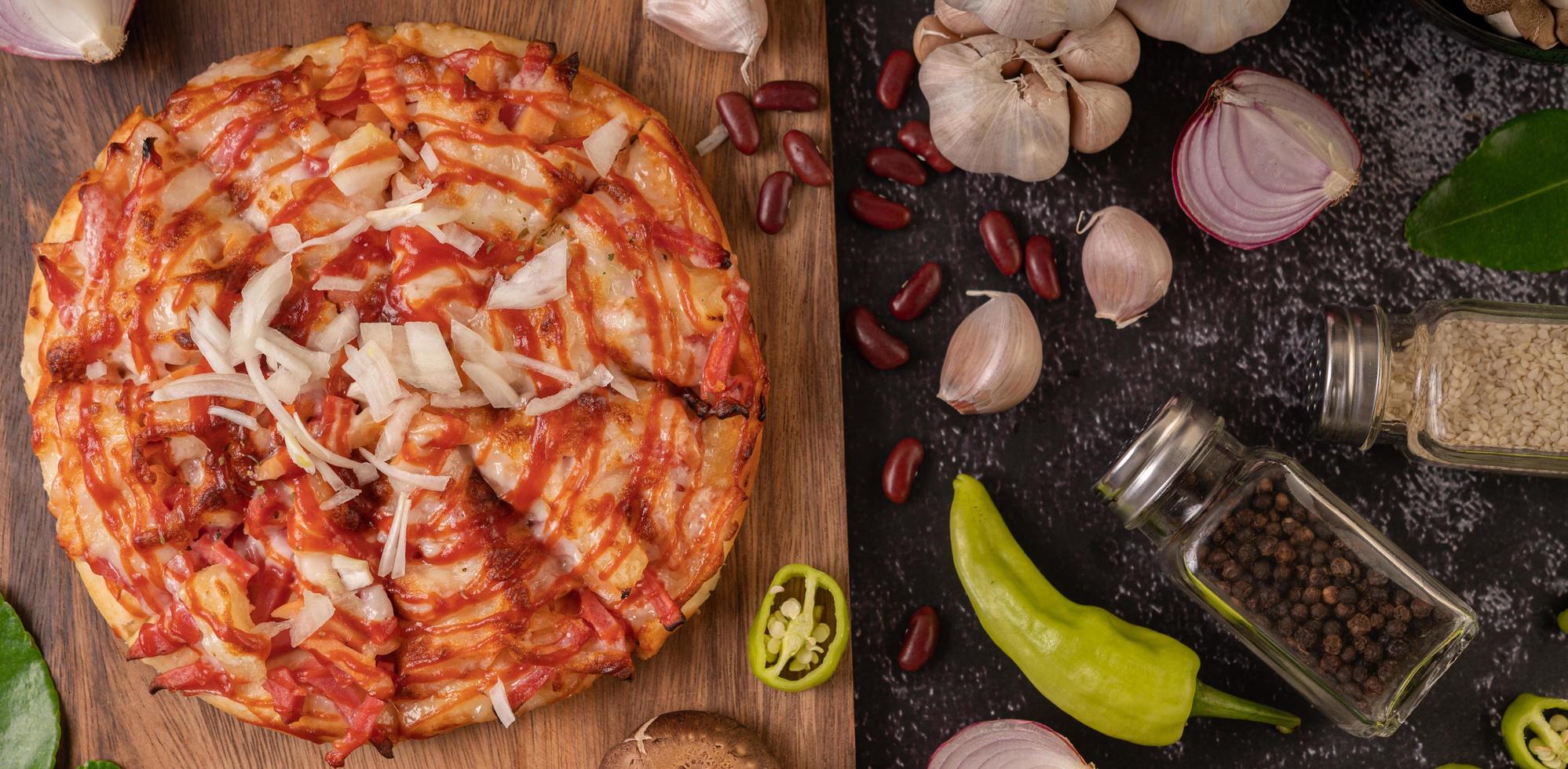 Pizza on a wooden board with bell peppers, garlic, chili and shiitake mushrooms photo