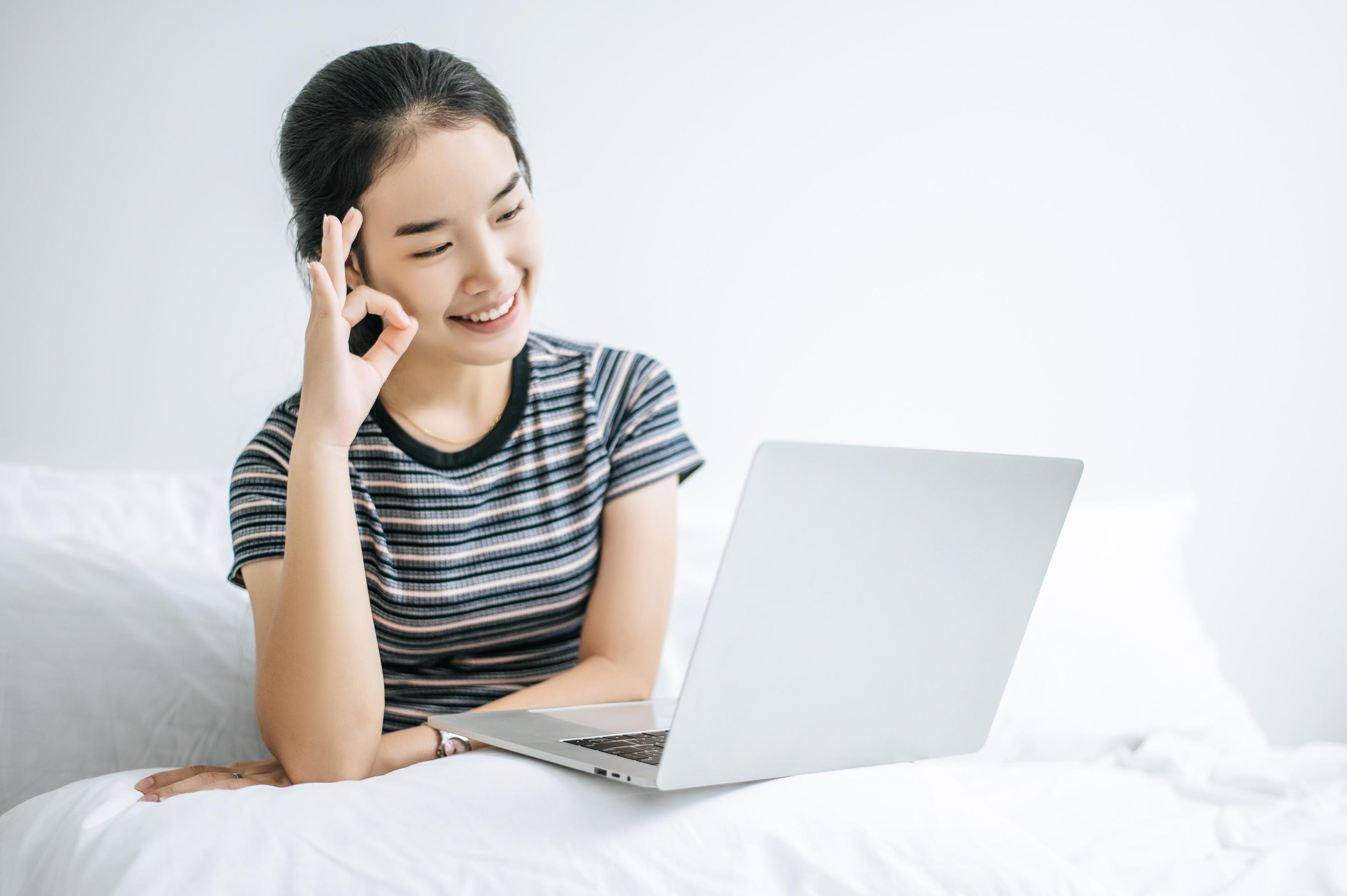 A Young Woman Playing On Her Laptop In Bed 1964107 Stock Photo At Vecteezy