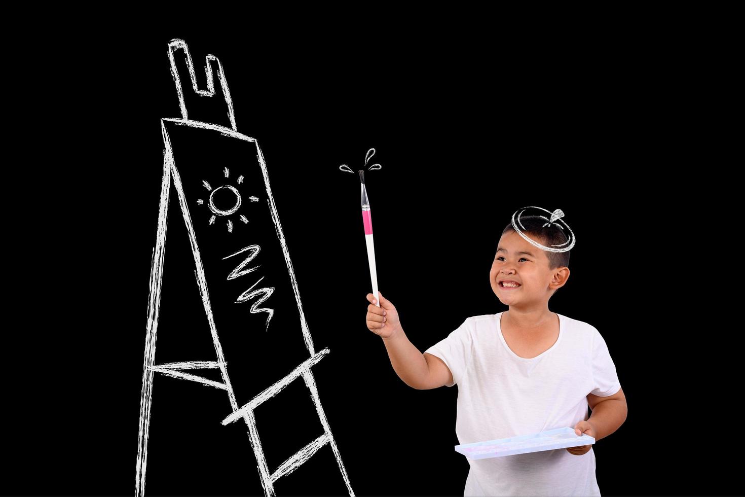 niño joven artista dibujando en una pizarra foto