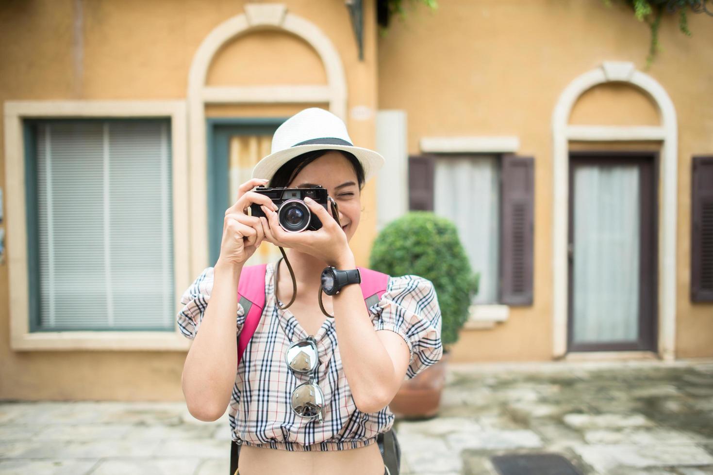 Portrait of pretty young hipster woman having fun in the city with camera photo