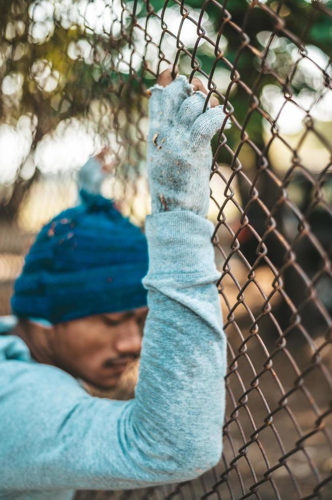 Beggars at a fence with homeless messages please help photo