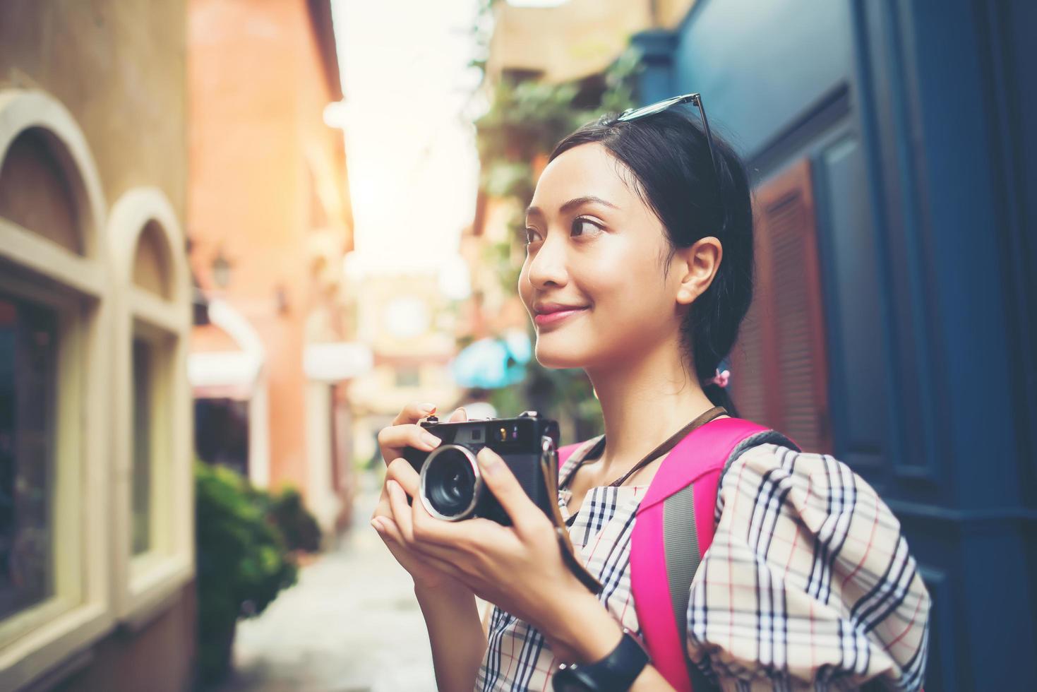 Primer plano de una joven inconformista viajando y tomando fotos con su cámara