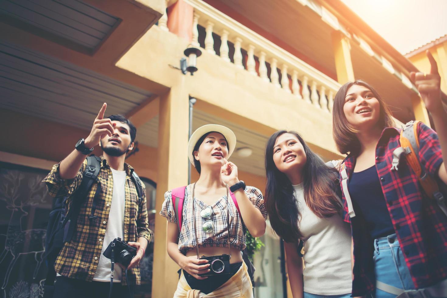 Grupo de jóvenes amigos felices divirtiéndose caminando en una calle urbana foto