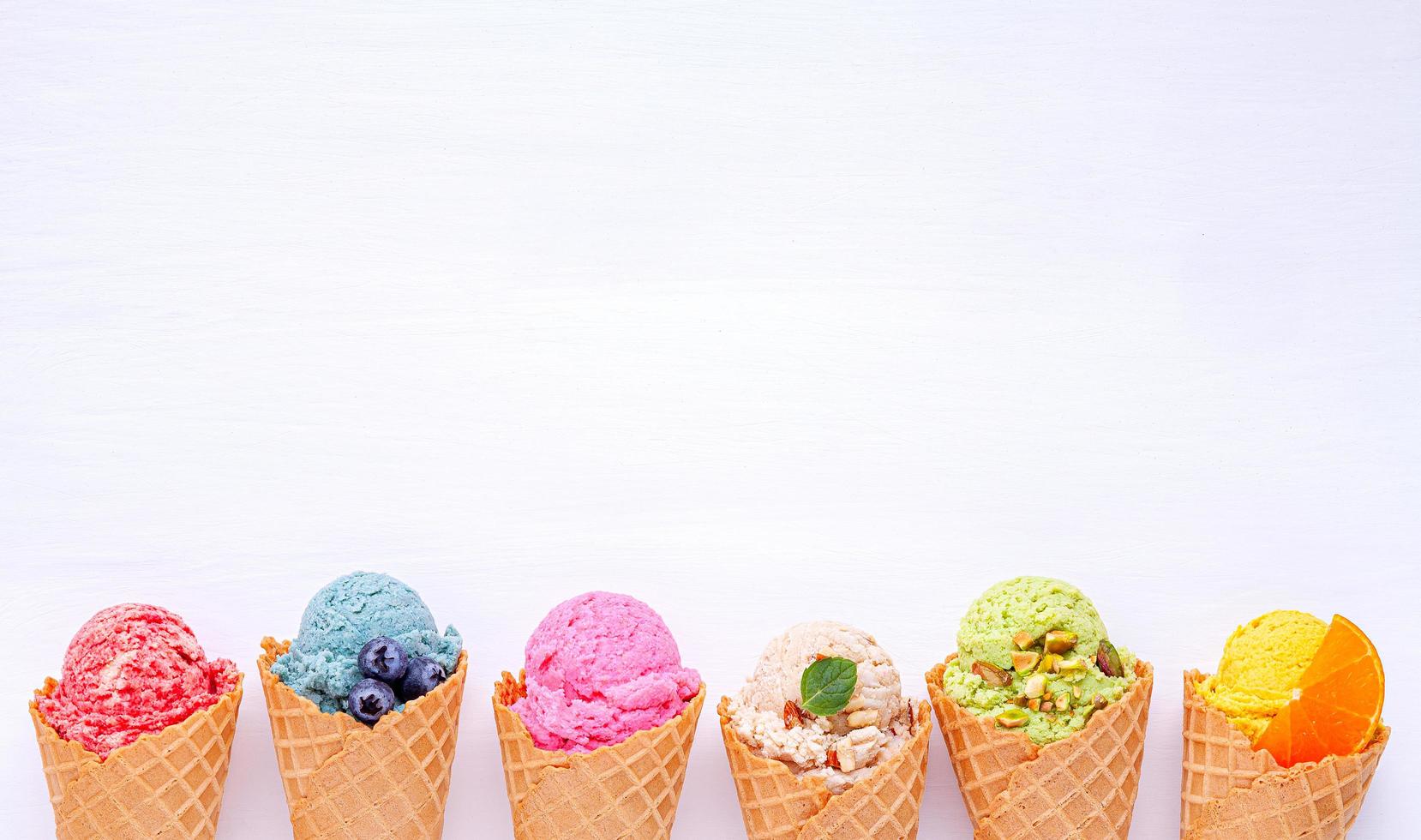 Various of ice cream flavor in cones blueberry, strawberry, pistachio, almond, orange and cherry. photo