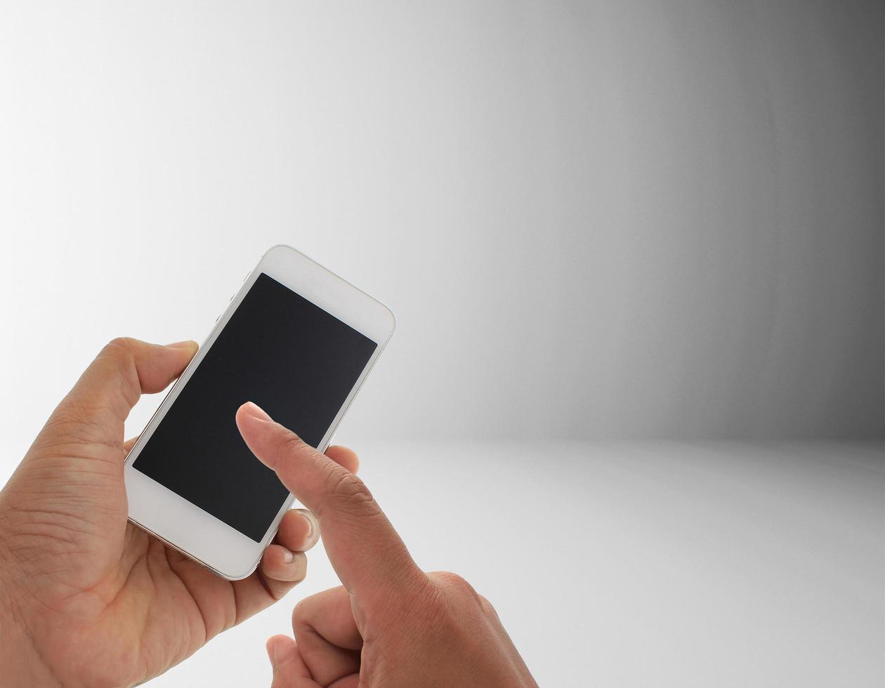 mano sujetando el teléfono sobre fondo gris foto