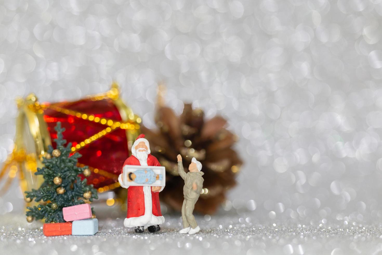 Figuras en miniatura de personas colocando adornos navideños foto