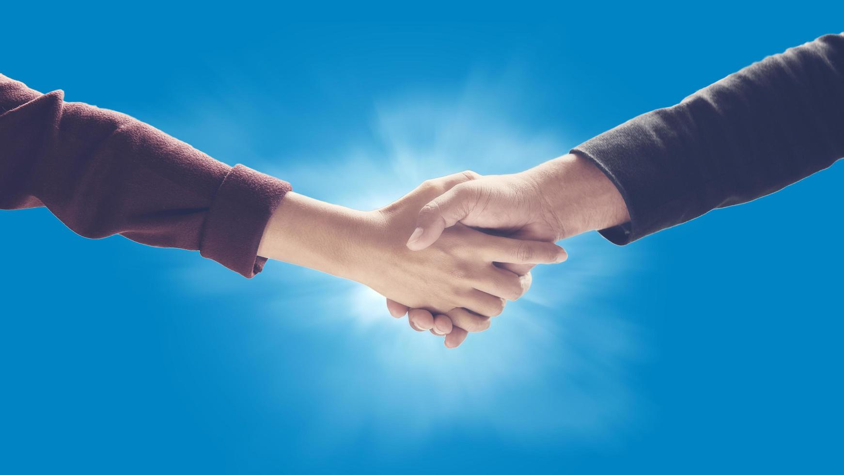 Business handshake against blue background photo