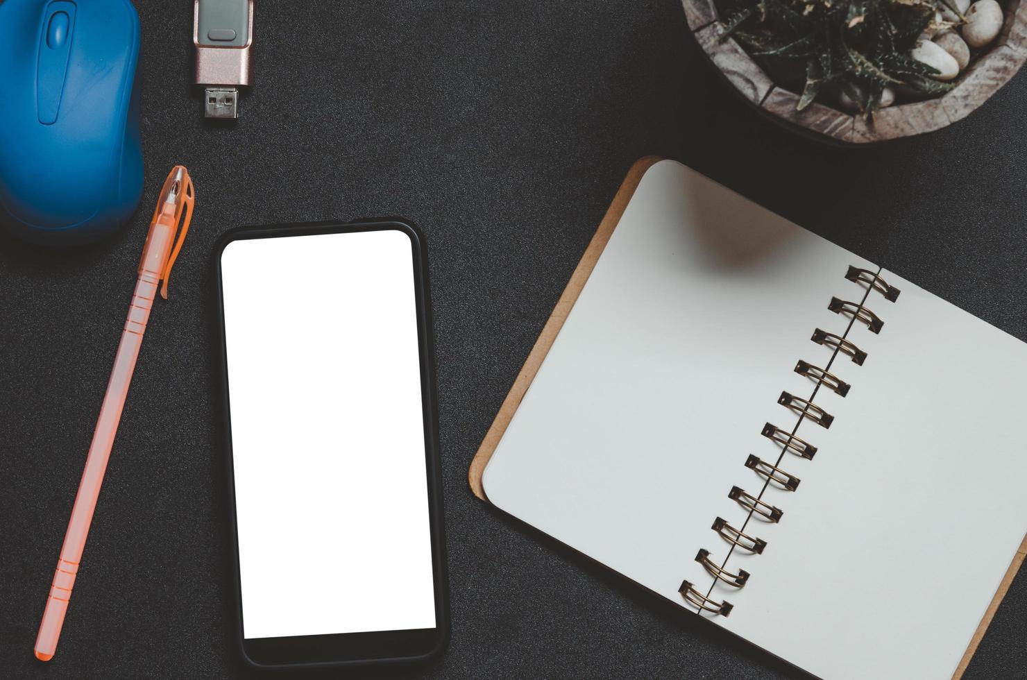 Top view of phone, notebook, and pen on a desk photo