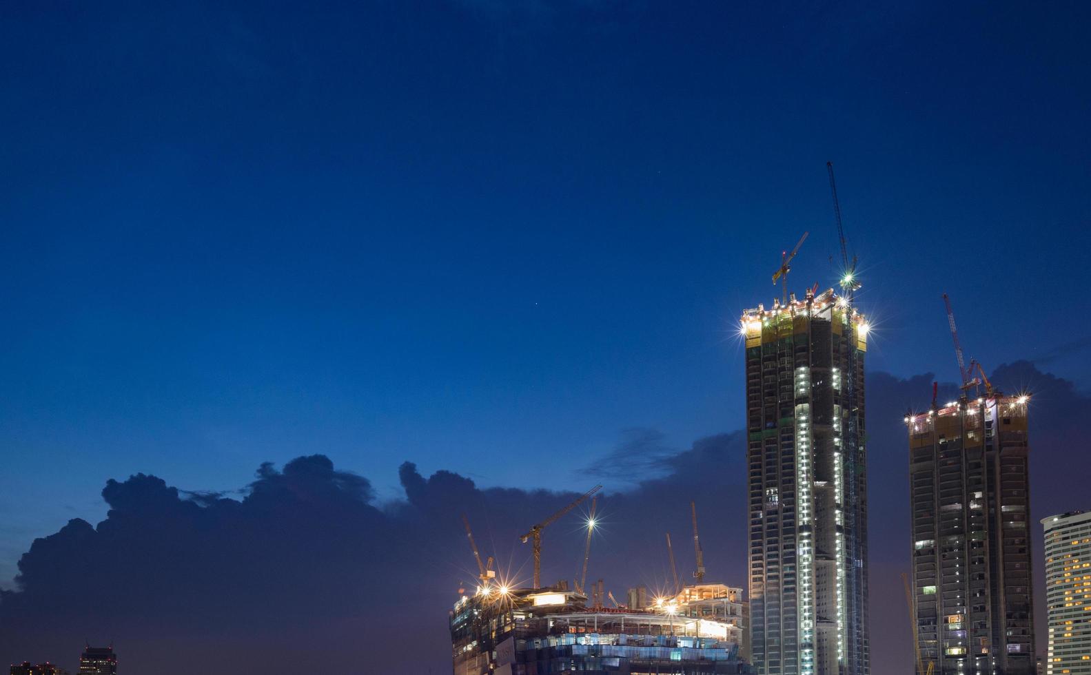 Grúas de construcción en Bangkok por la noche foto