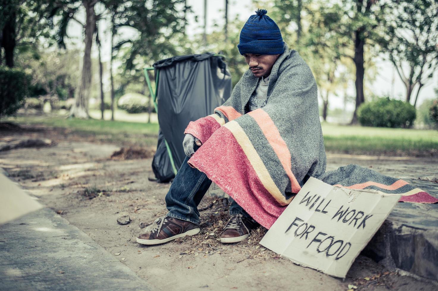 Homeless man with cardboard sign photo