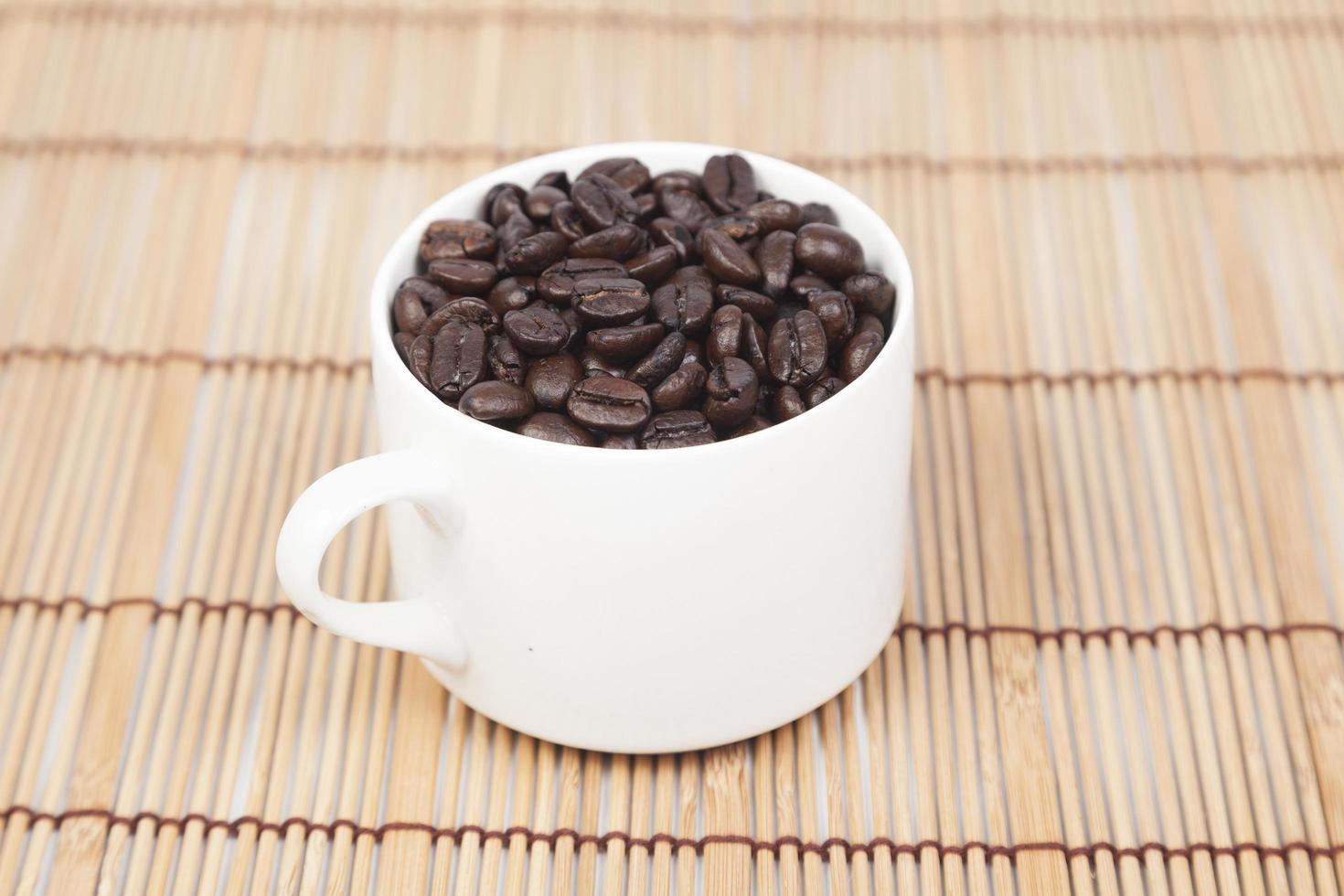 granos de cafe en una taza blanca foto