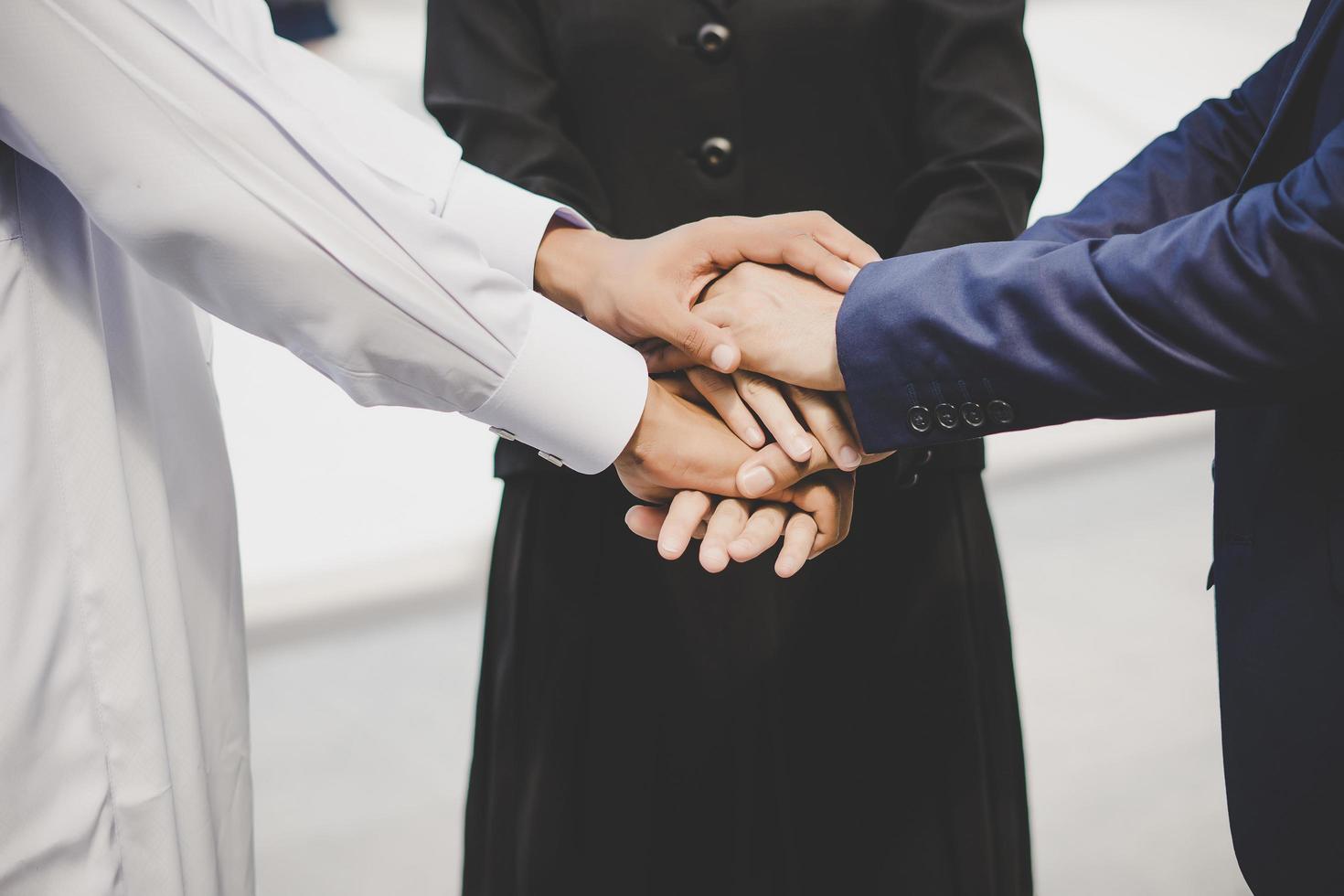 Business team stacks hands in support of start up project photo