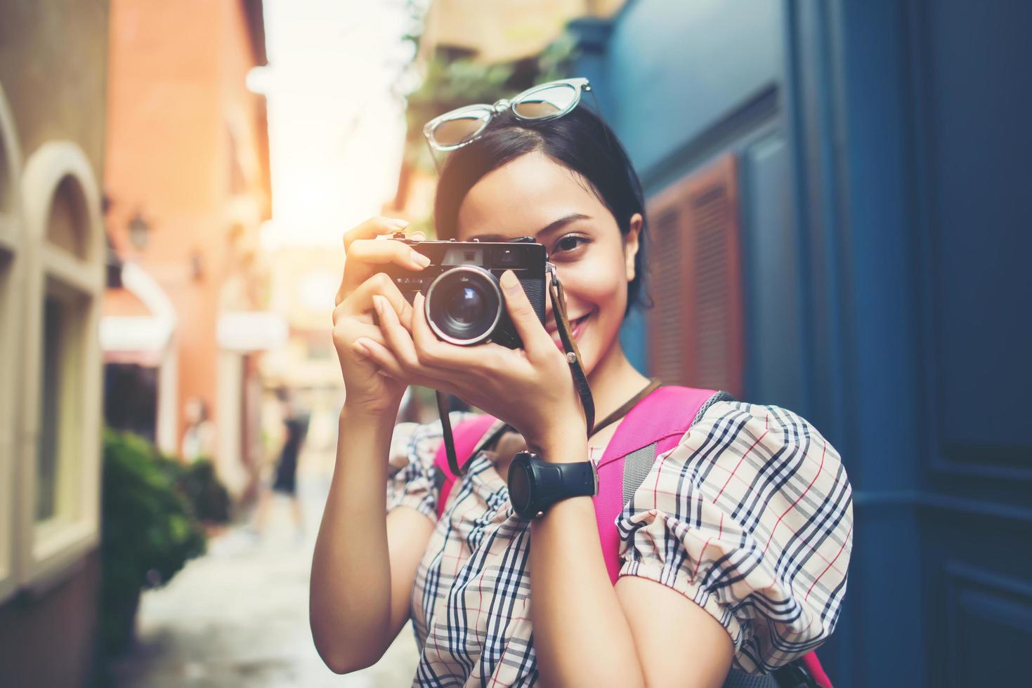 primer plano, de, un, joven, hipster, mujer, mochilero, y, tomar fotos, en, un, área urbana foto