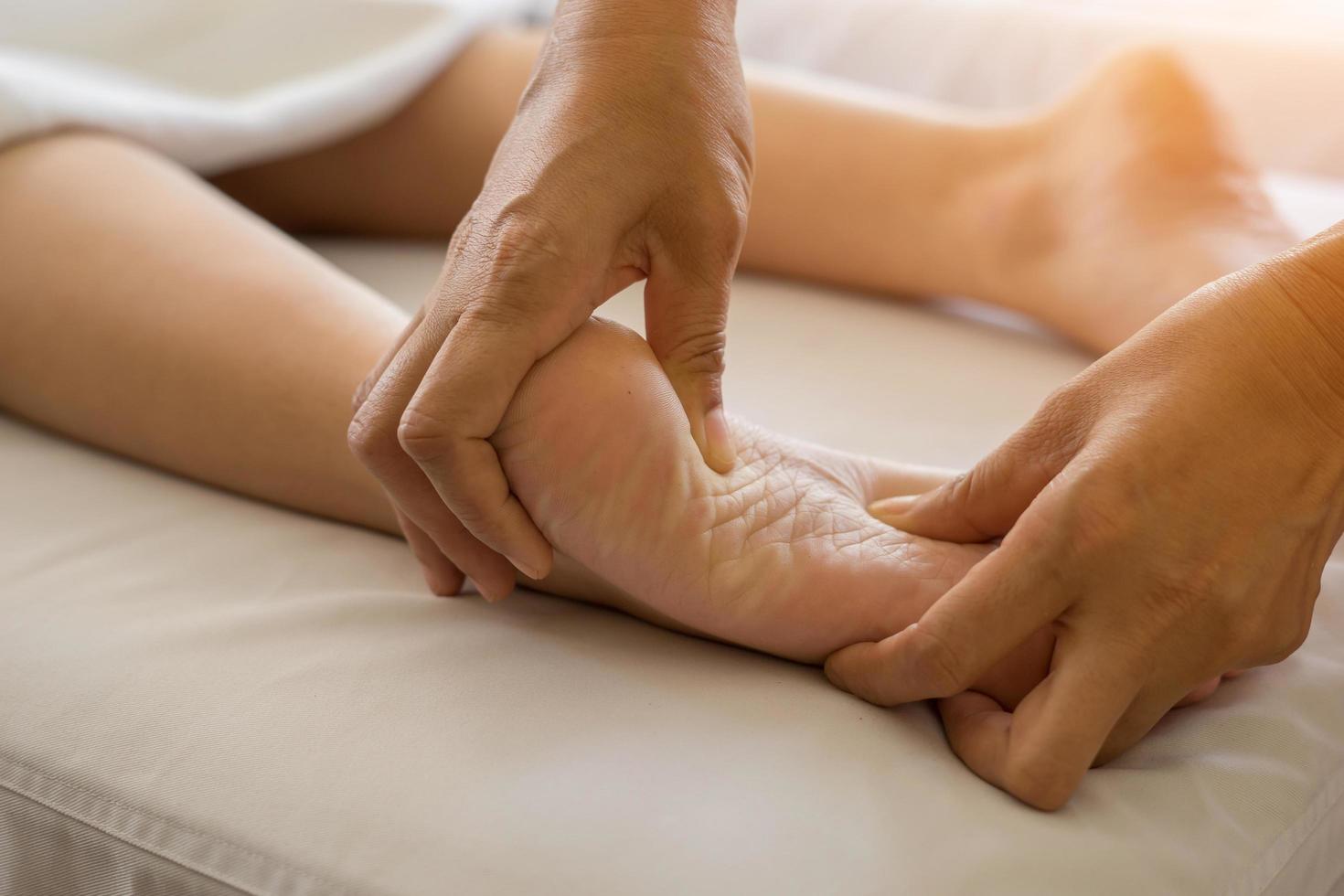 Close-up of woman doing foot massage at spa photo