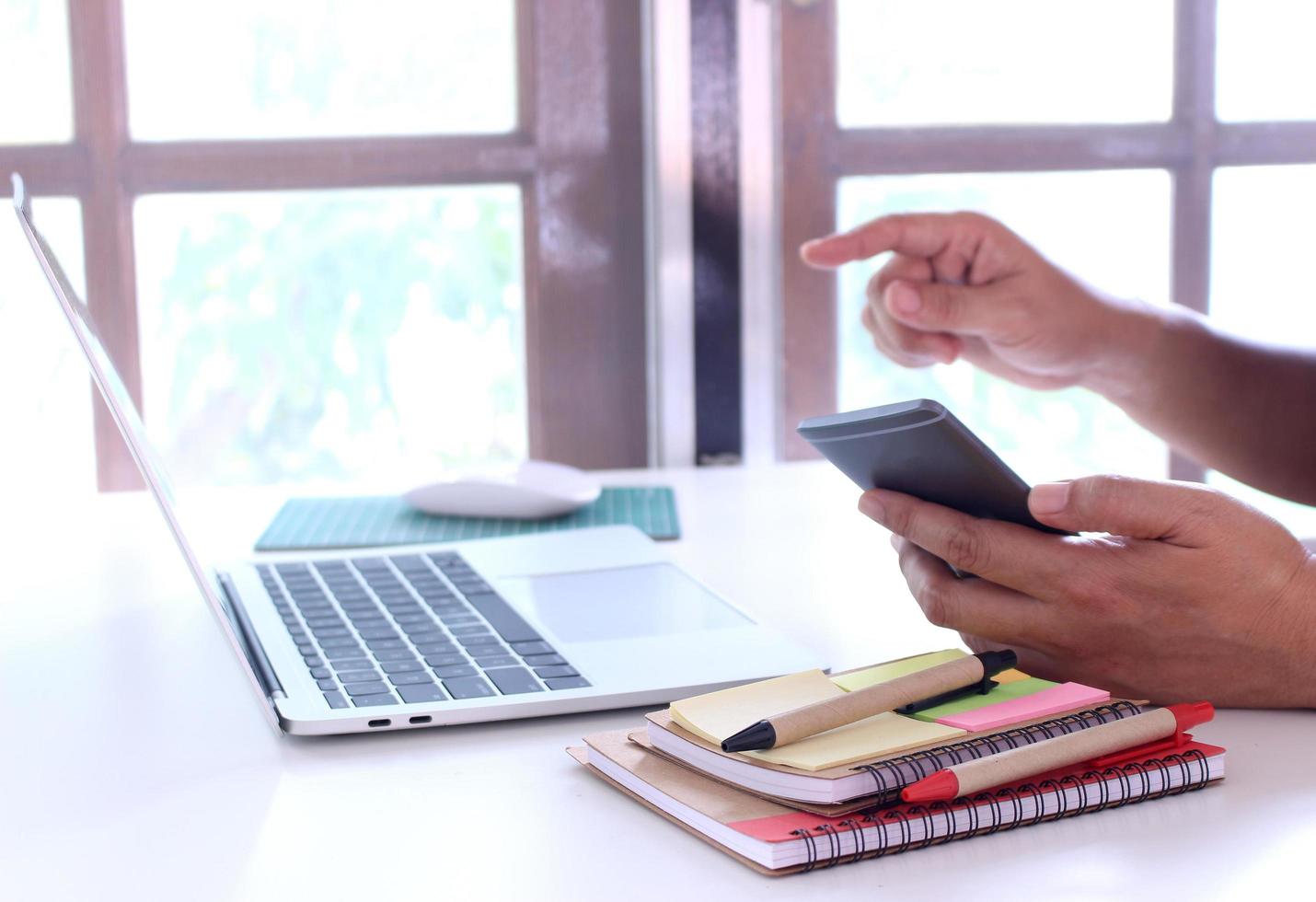 Person using phone and laptop photo