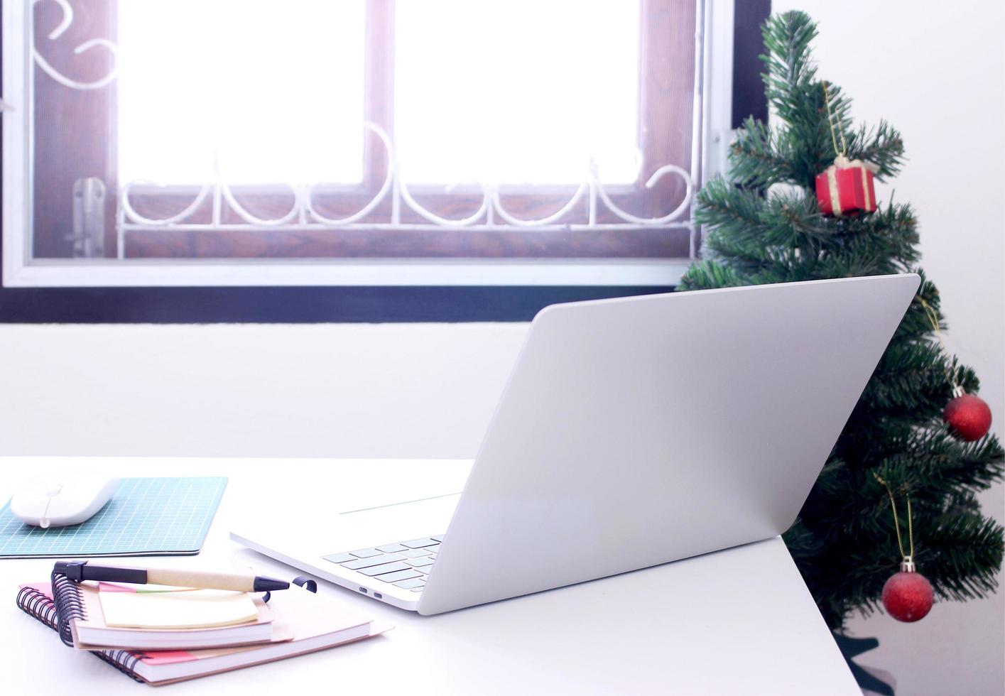 Laptop on office desk with Christmas tree photo