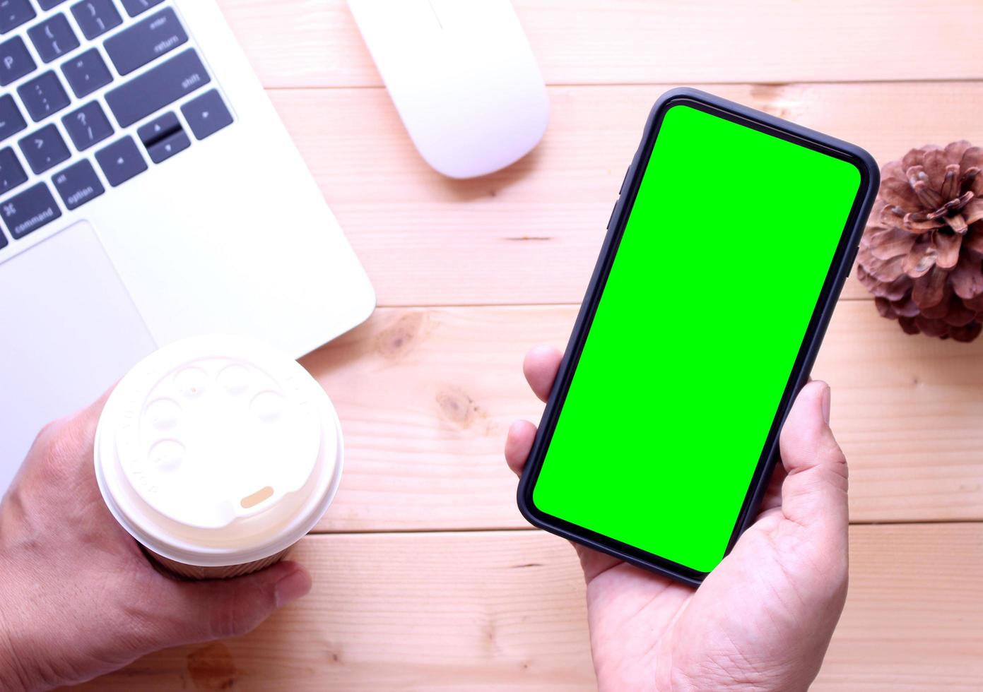 Person holding phone mock-up in office photo