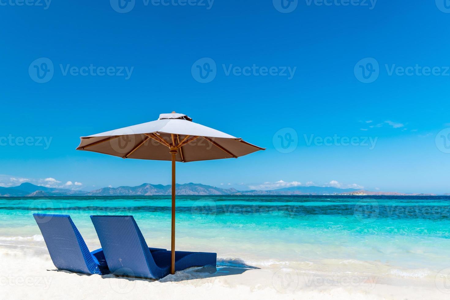 Sunbeds with umbrella on the sandy beach photo