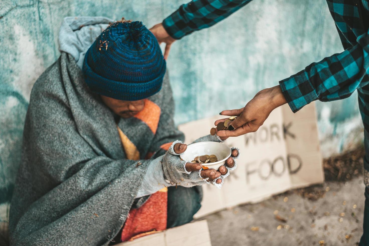 Person gives to a beggar on the side of the road photo