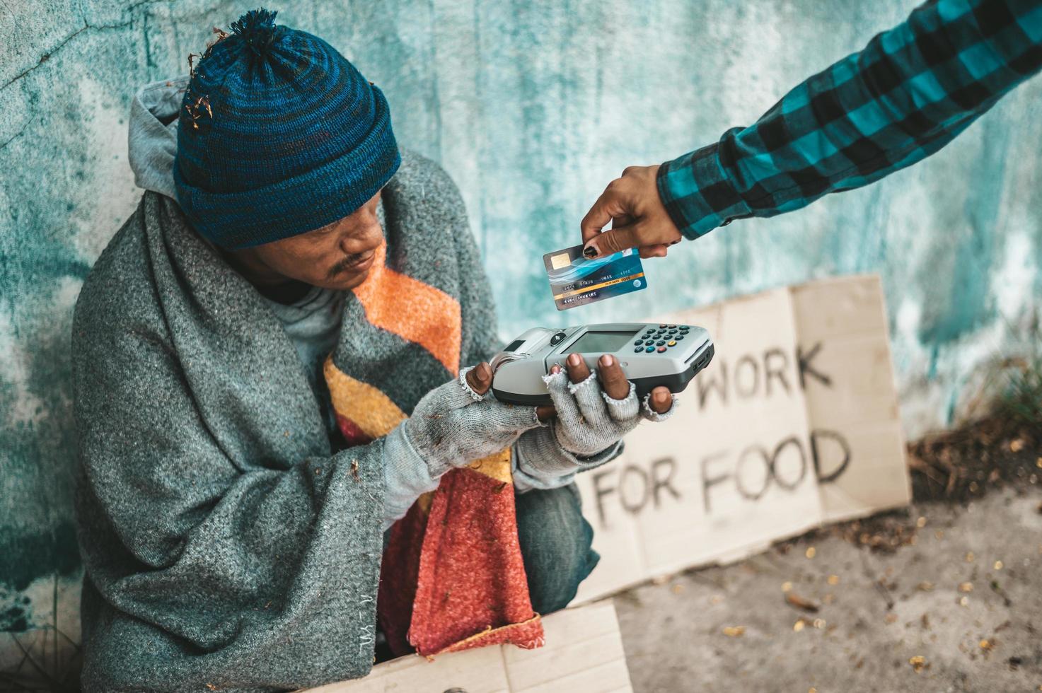 Person gives to a beggar on the side of the road photo