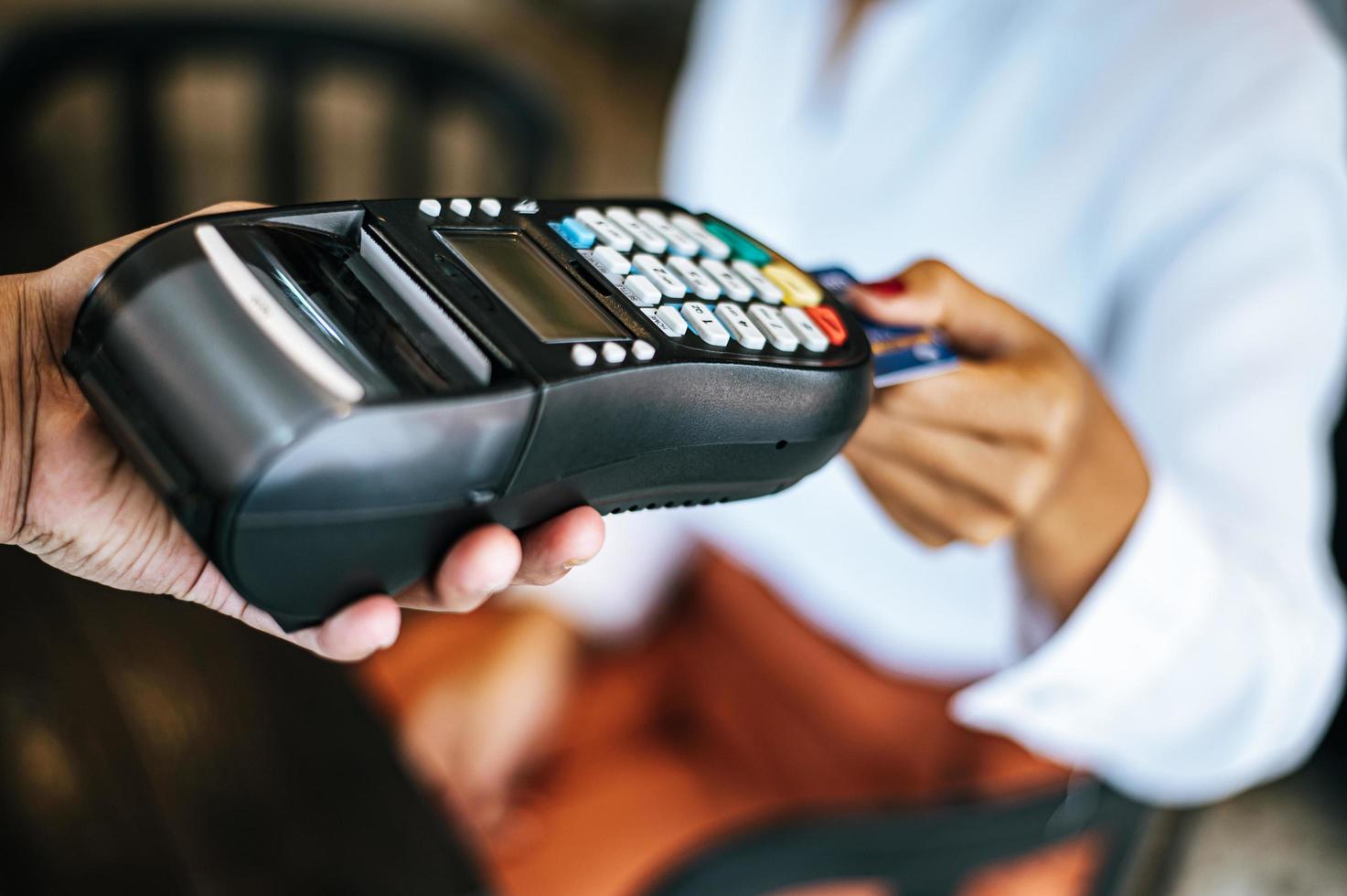 Close-up of woman paying with credit card in cafe photo