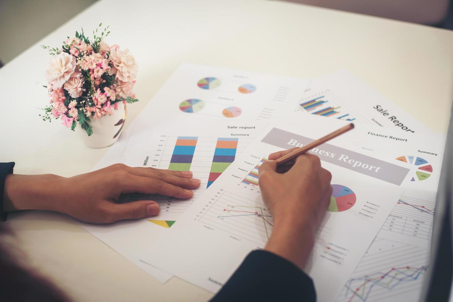 Mujer de negocios sosteniendo un lápiz trabajando con gráfico de negocios foto