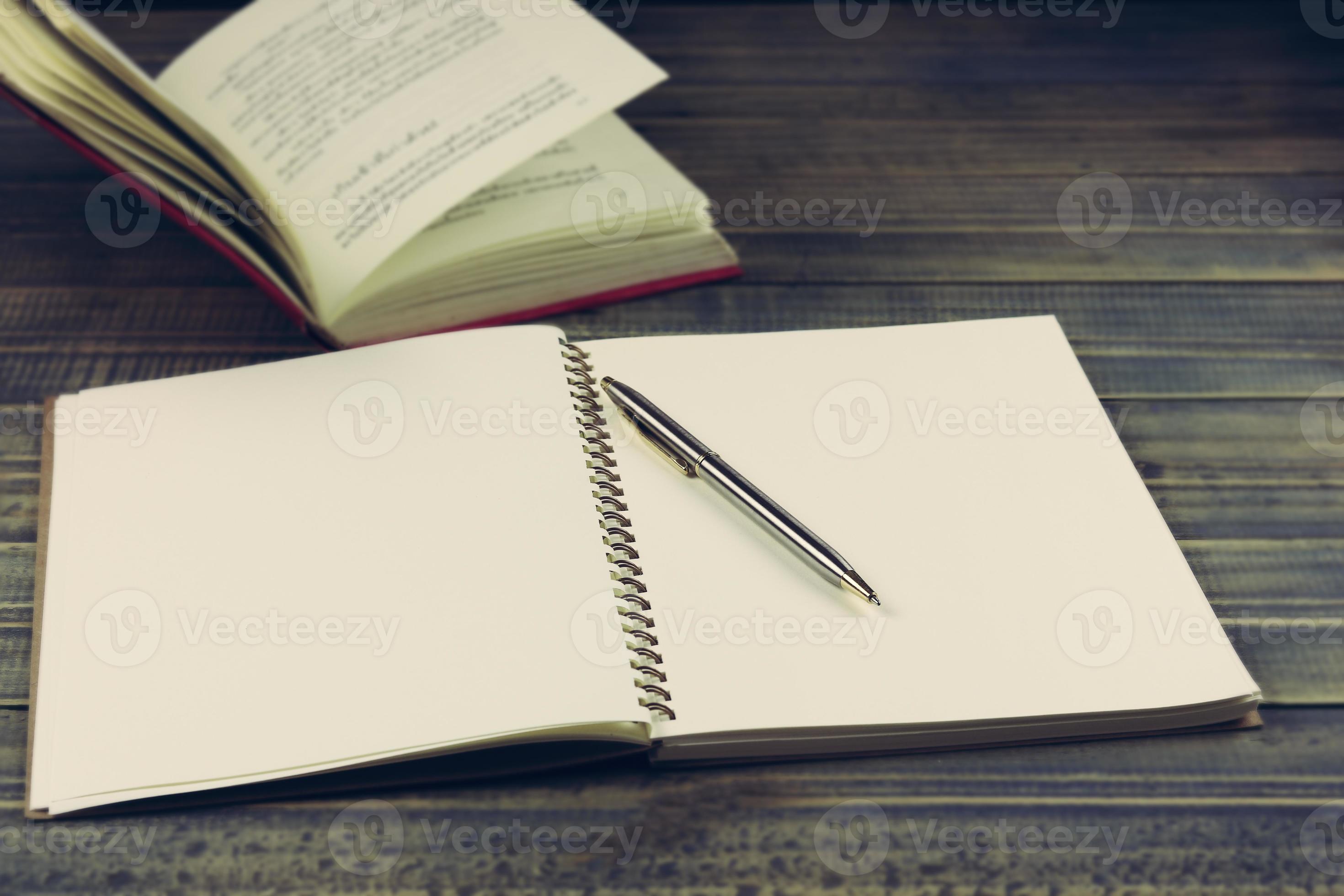 Book and pen on table with copy space 1976216 Stock Photo at Vecteezy