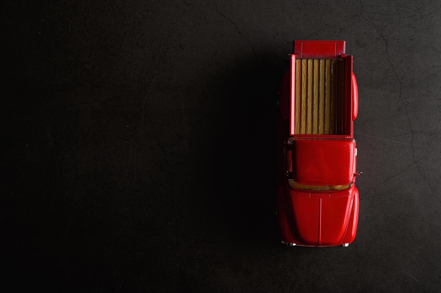 Red pickup model truck on a black floor photo