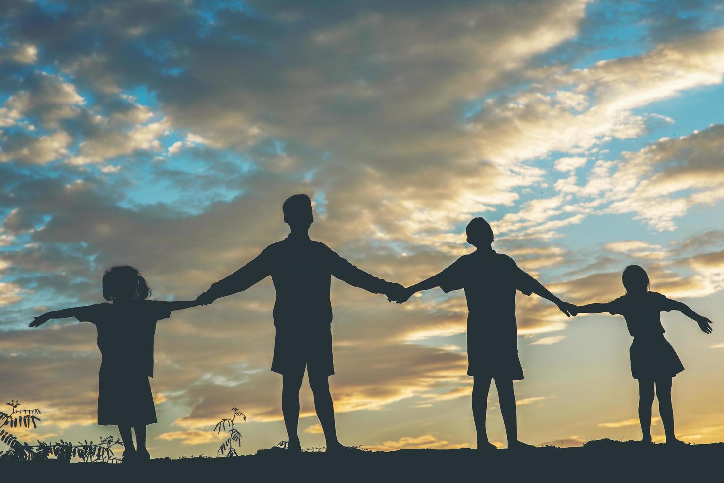 Sunset silhouette of children playing photo