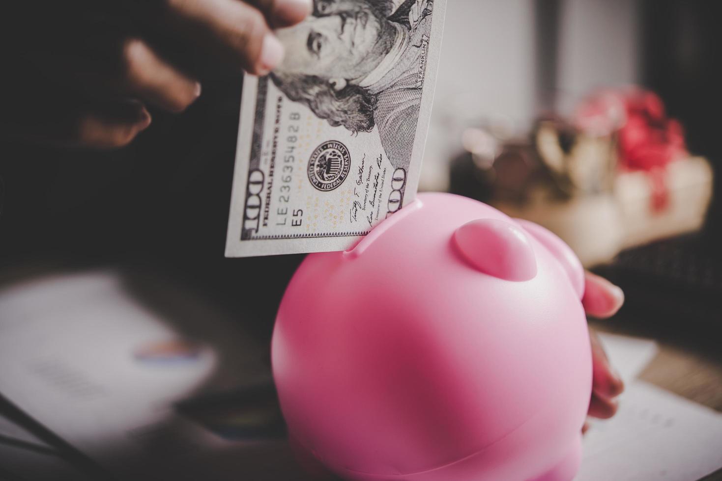 Woman putting euro banknote into a piggy bank photo