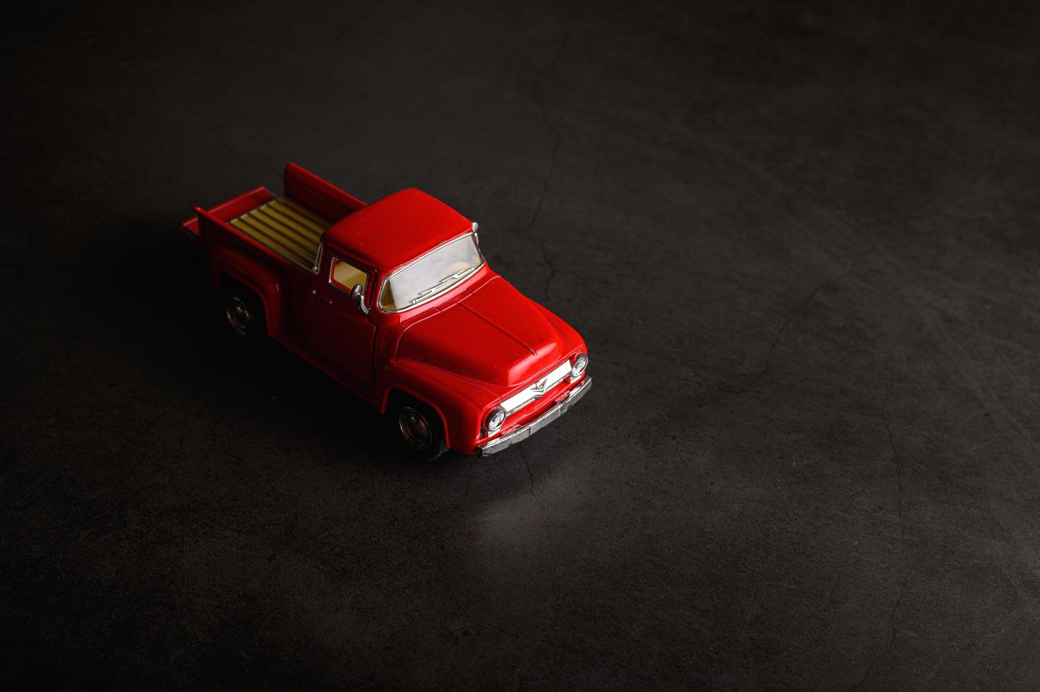 Red pickup model truck on a black floor photo