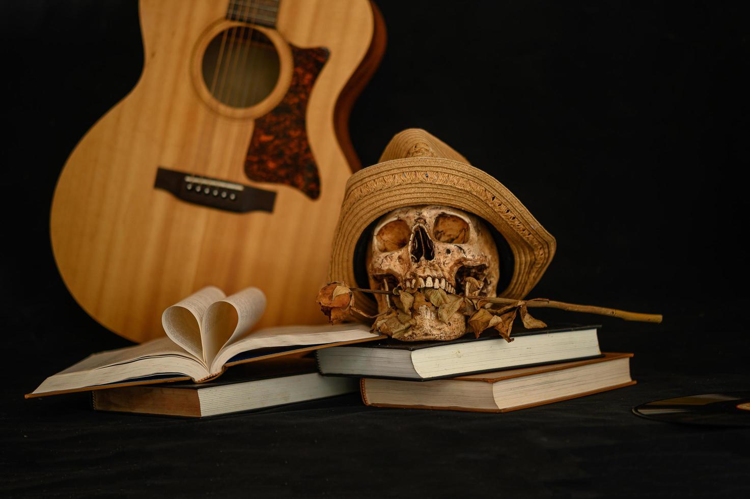 naturaleza muerta con un libro en forma de corazón y una calavera con flores secas foto