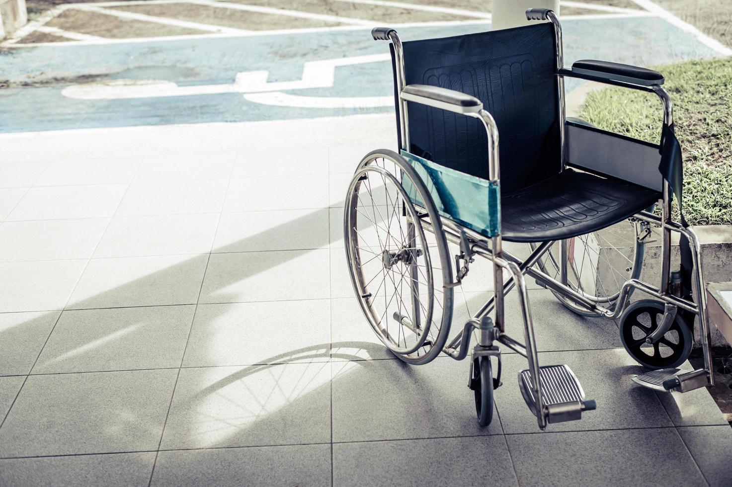Paciente en silla de ruedas estacionada frente al hospital. foto
