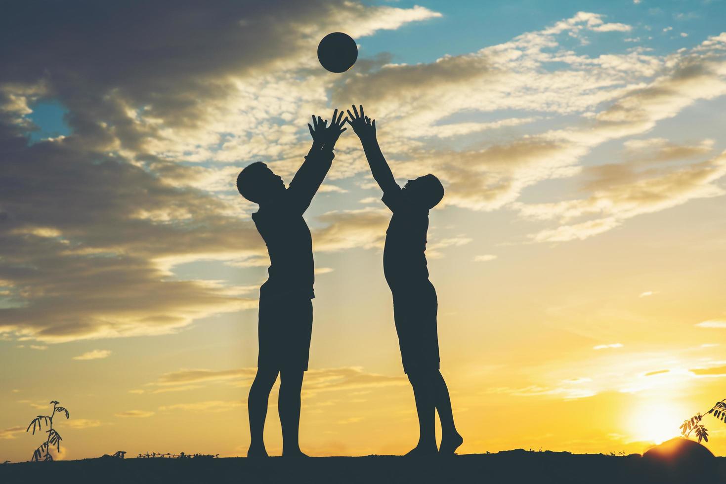 Silhouette of children playing soccer football photo