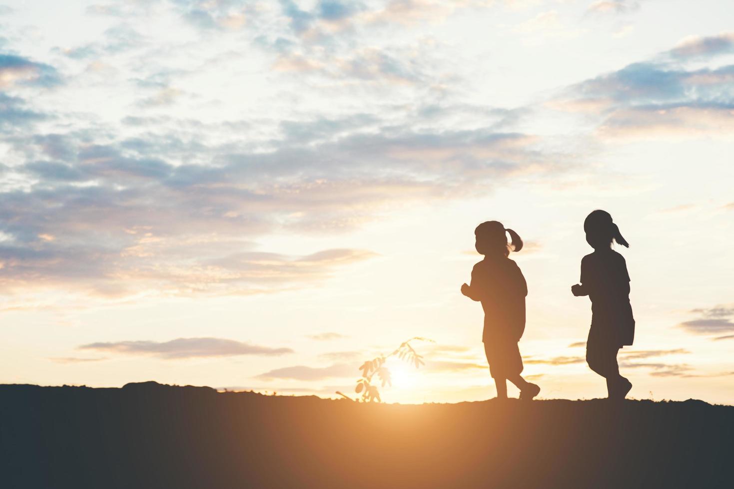 Sunset silhouette of children playing photo