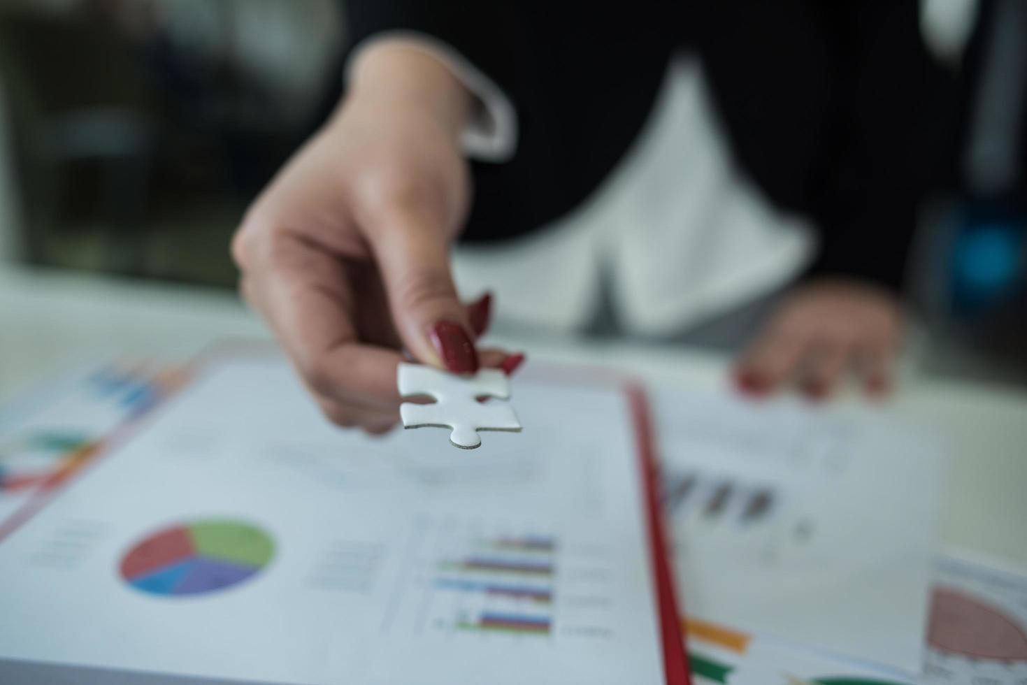 Business woman handing over a puzzle piece photo