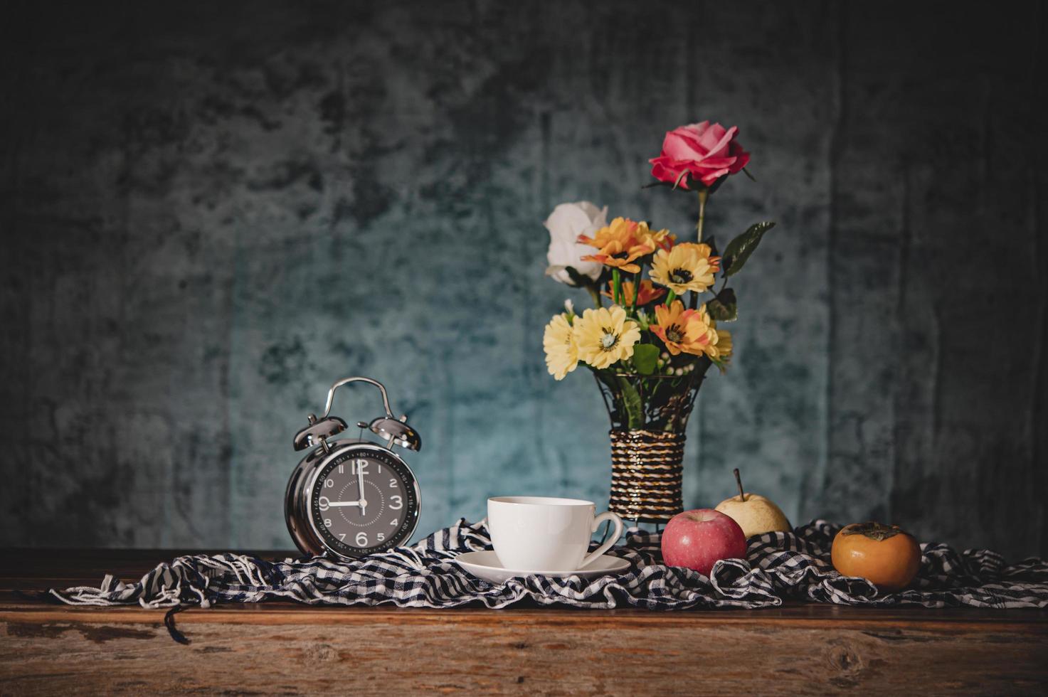 naturaleza muerta con jarrones, flores, frutas, tazas de café y relojes foto