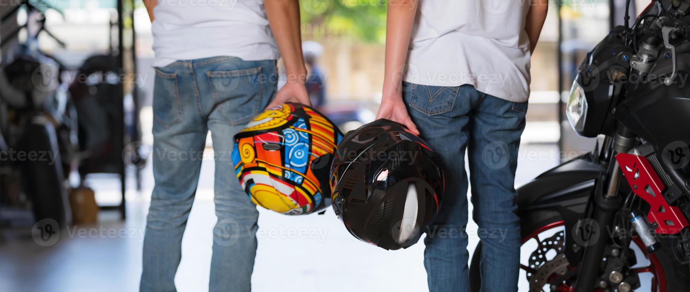 Traveling couple carrying motorcycle helmets photo