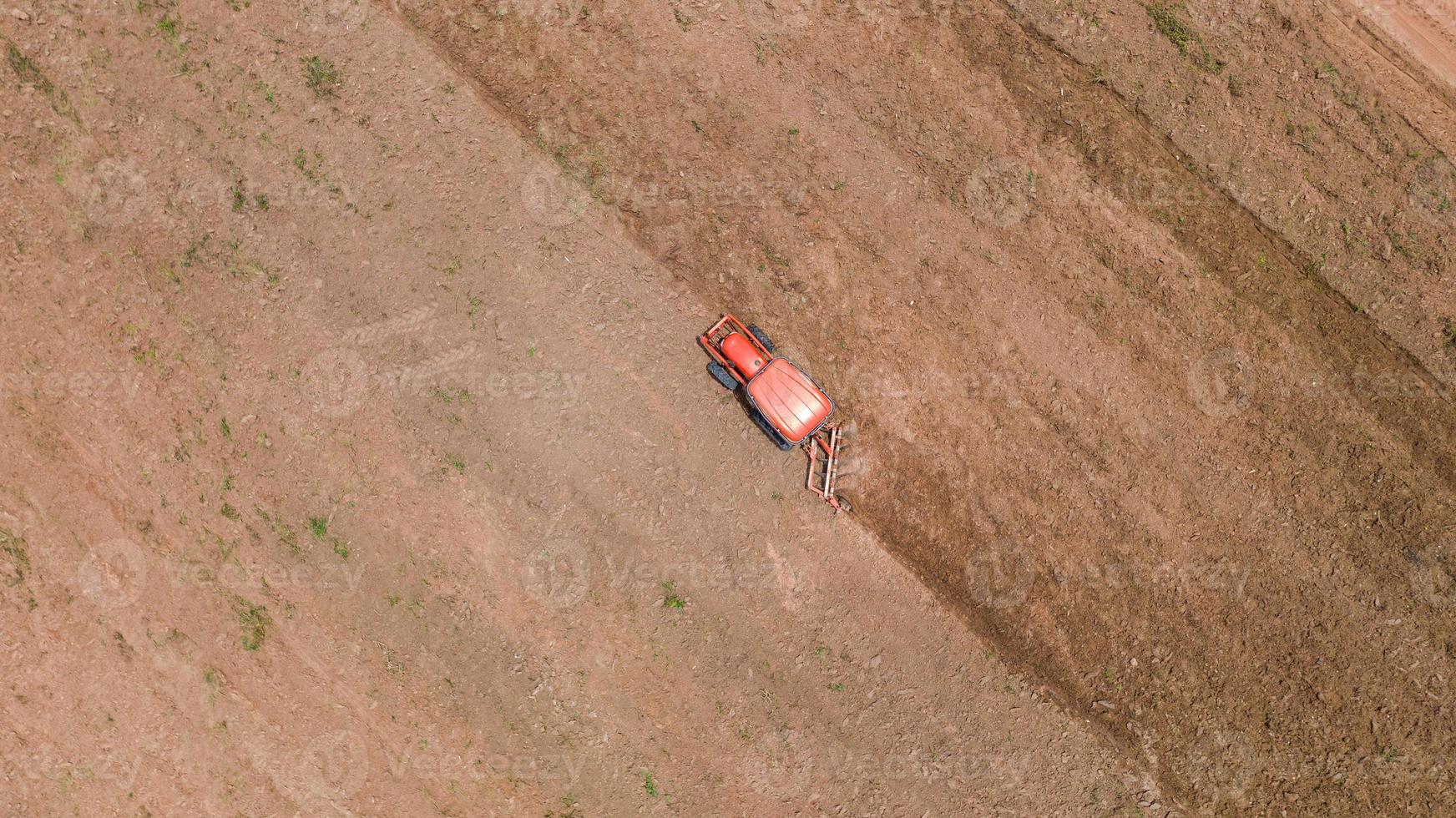 Agricultural tractor in a dirt field photo