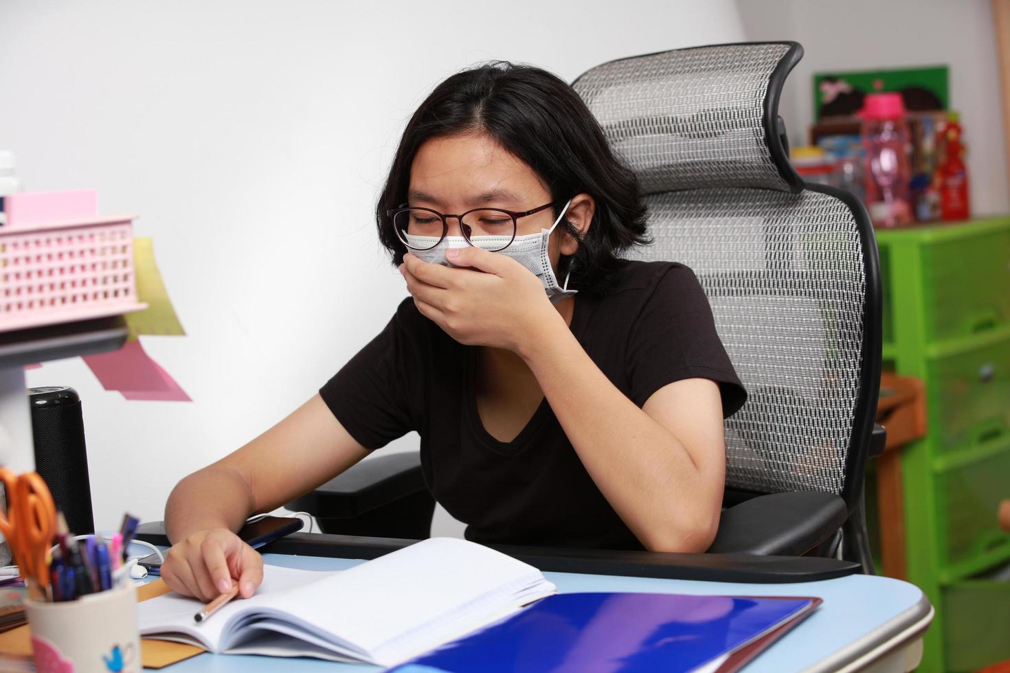 Girl wearing a health mask sneezing from being sick quarantined and staying at home photo