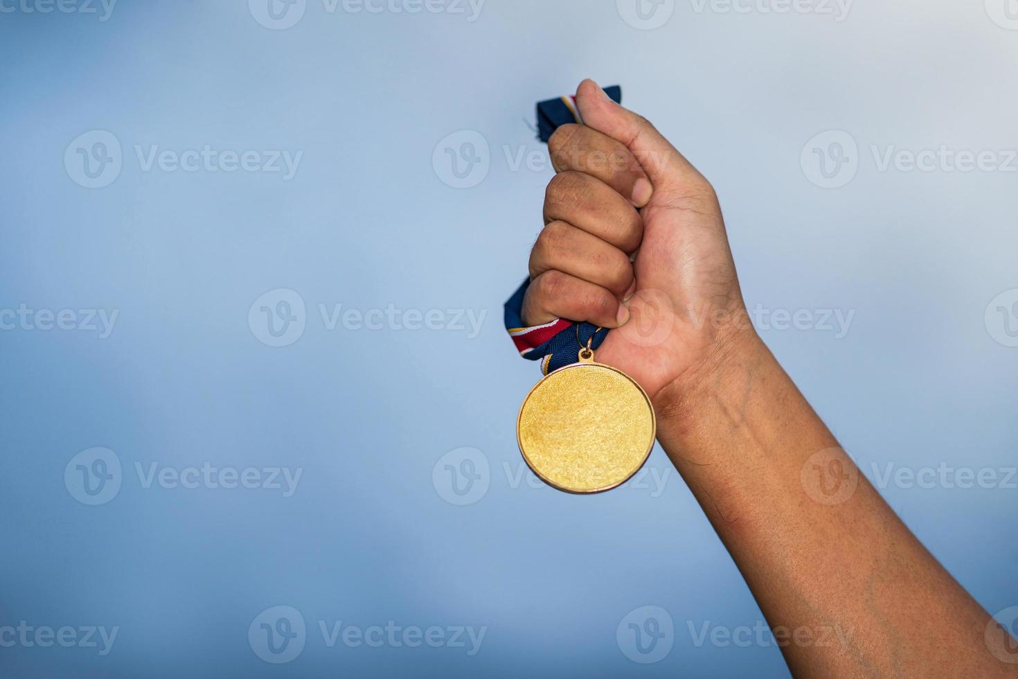 persona sosteniendo una medalla foto