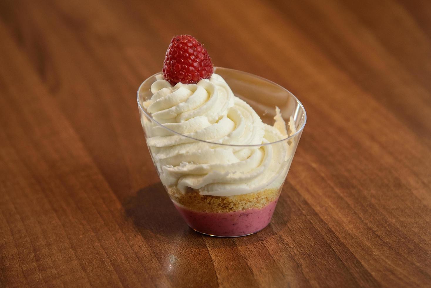 Raspberry dessert with whipped cream in a glass photo