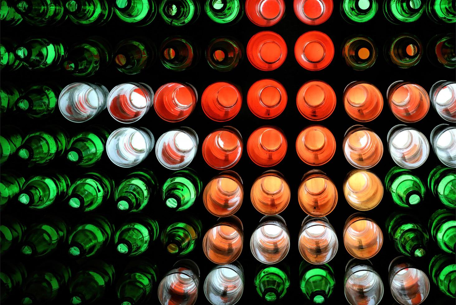 Decoración colorida de botellas con iluminación nocturna, decoración de pared hecha con botellas reutilizadas. foto