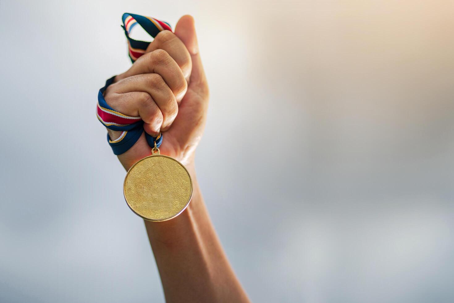 Hand holding a gold medal photo