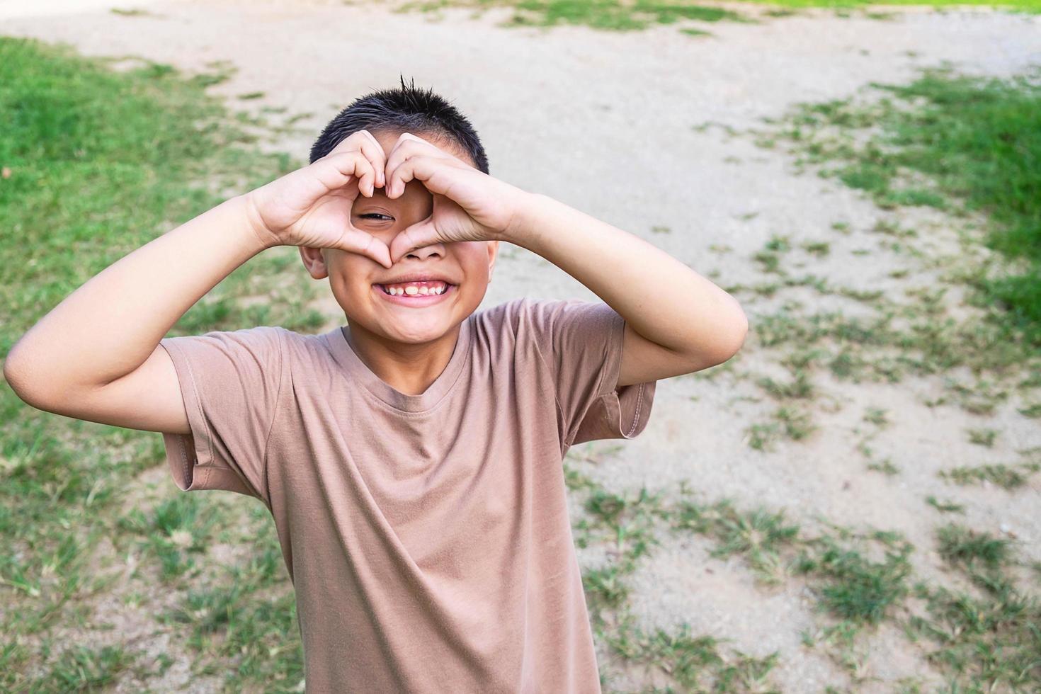 niño haciendo un corazón con las manos foto