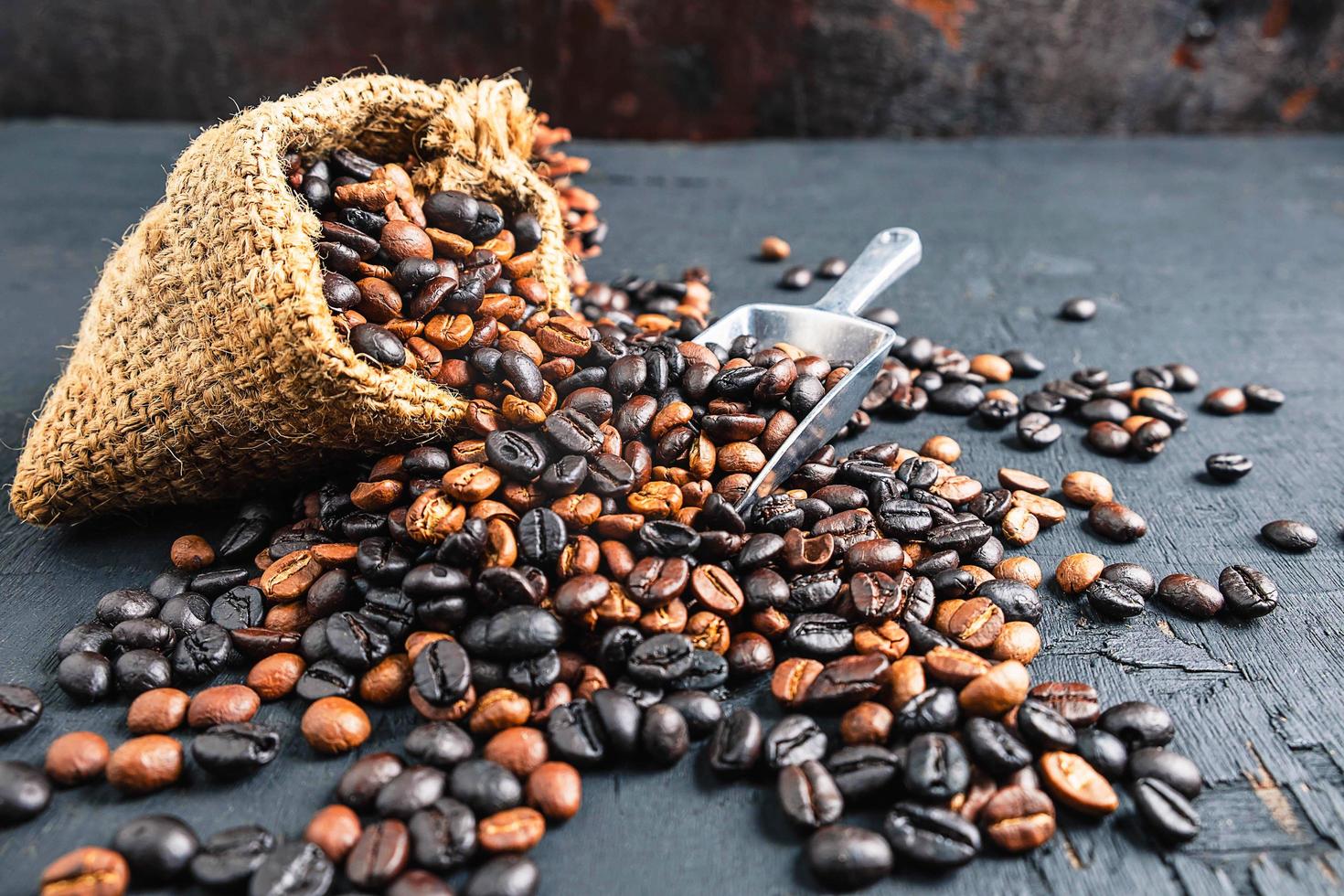 granos de café en una bolsa de tela marrón foto